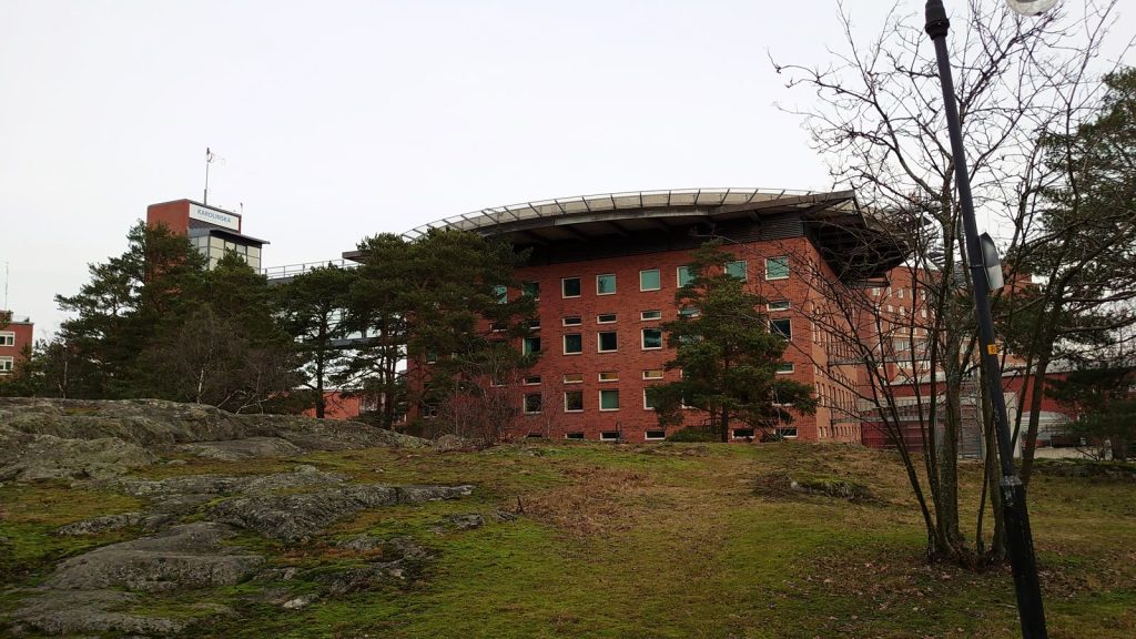 Karolinska universitetssjukhuset i Solna sett från en klippa, med sjukhusets skylt på tornet