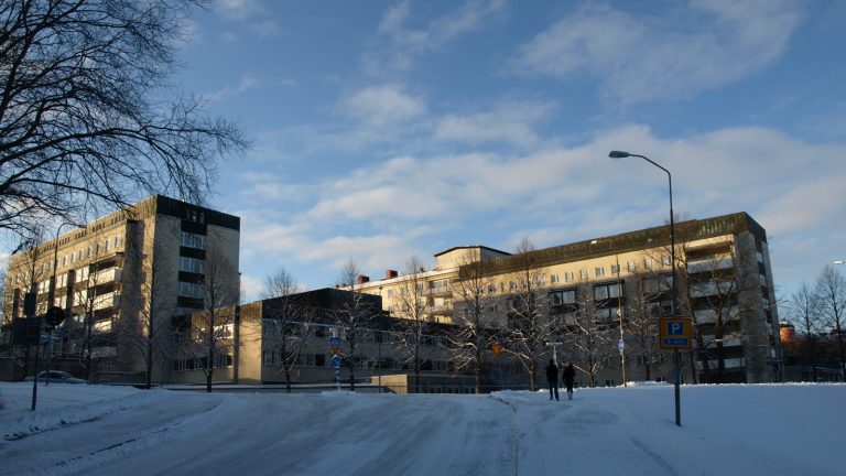 Akademiska sjukhuset i Uppsala en klar vinterdag, med snötäckta gator framför byggnaderna