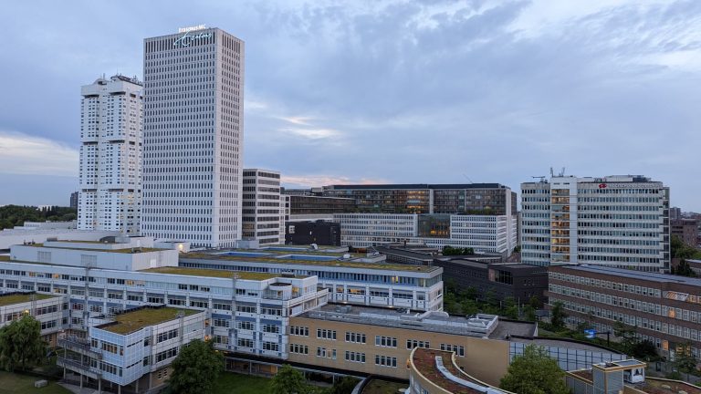 Erasmus MC:s sjukhusbyggnader i Rotterdam med det höga vita tornet och låga vårdbyggnader i förgrunden.